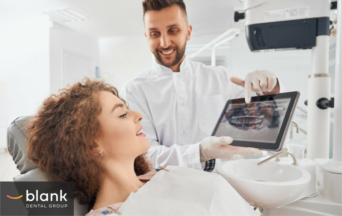 A dentist showing a dental X-ray on a table to a female patient.
