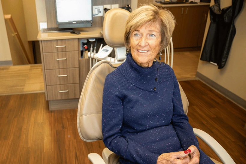 Woman smiling while sitting in a dental office